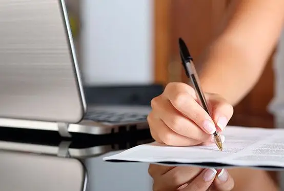 mano con boligrafo, firmando documento